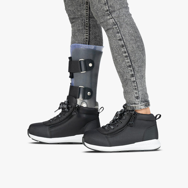 Toddler wearing Rugged Black BILLY Goat DZ High boots with dual zippers, designed for AFO compatibility and easy wear, emphasizing durability and convenience.