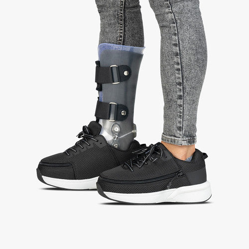 Woman wearing Black Limitless Low Top Shoes, featuring a wrap-around zipper for easy access, designed for comfort and independence with a modern, adaptive style.