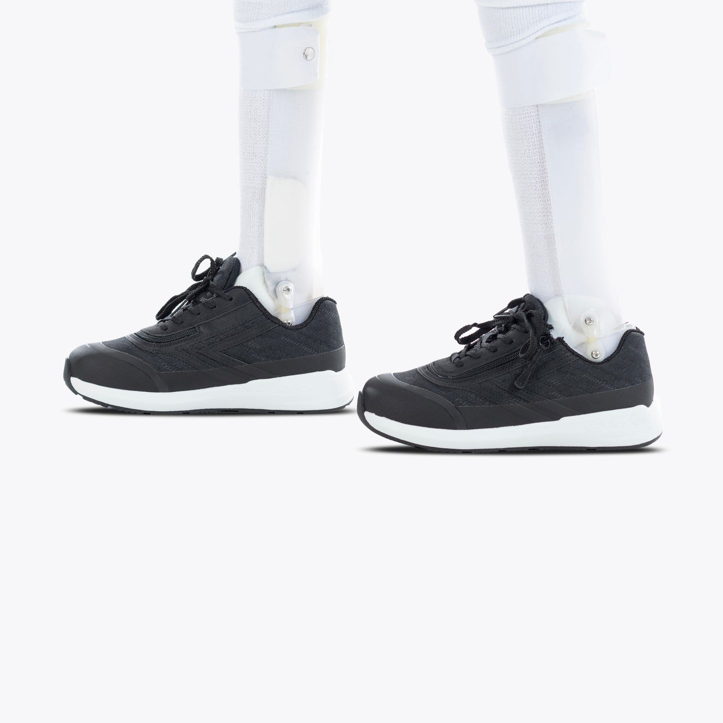 Black BILLY Goat shoes with white socks, featuring a prosthetic leg. AFO-friendly design with a short wrap zipper for easy wearing.