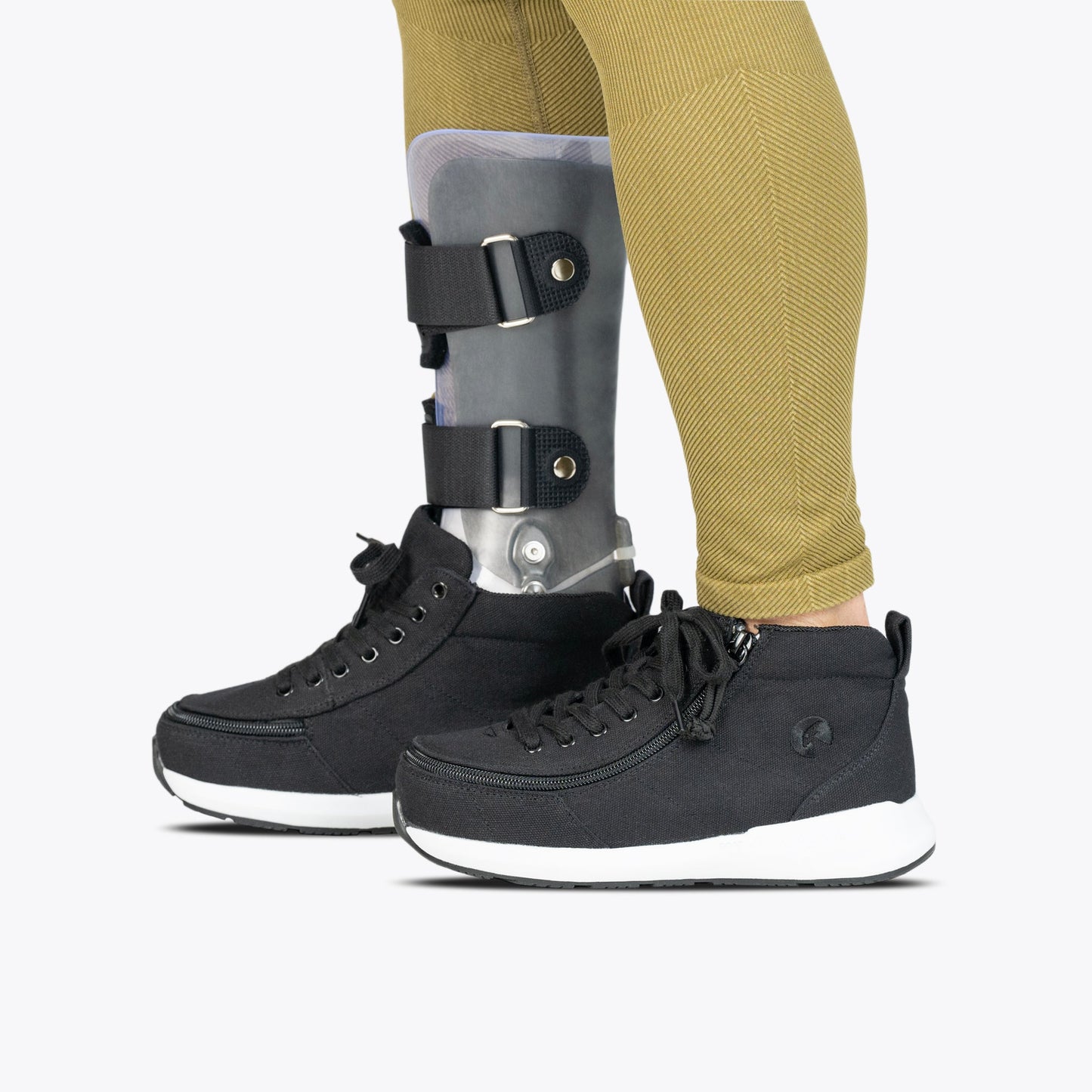 Person wearing Black BILLY Goat Classic High AFO-Friendly Shoes with a leg brace, featuring a full-wrap zipper for easy access.