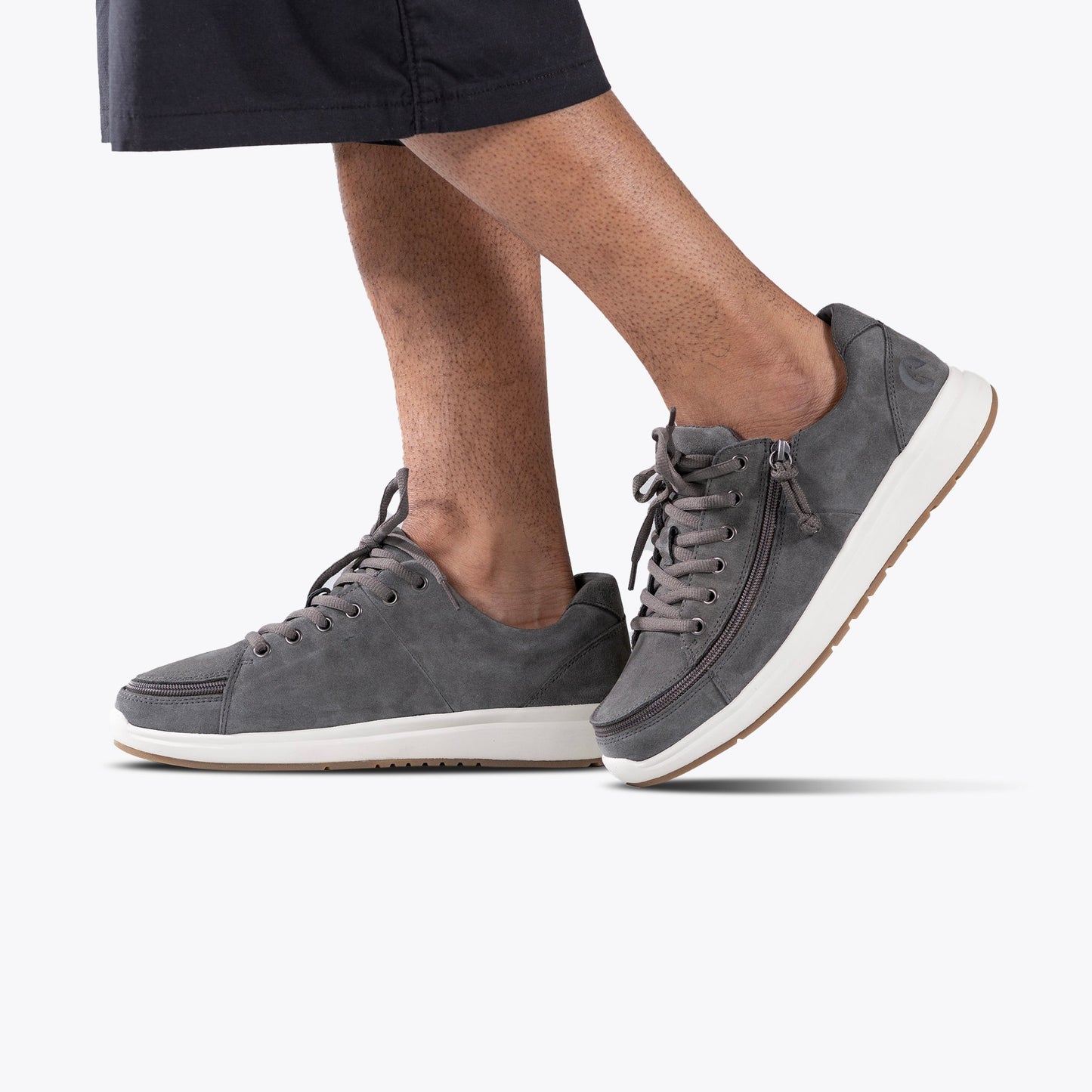 Men's Grey Suede BILLY Comfort Low shoes with wraparound zipper, shown on legs wearing black shorts, highlighting ease of wear and stylish design.