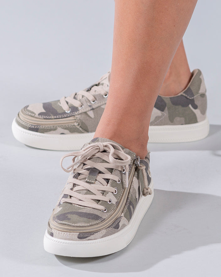 Women's Natural Camo BILLY Classic Lace Lows: Camouflage sneakers featuring printed canvas upper, rubber tread outsole, and adjustable cotton-blend laces, worn by a person.