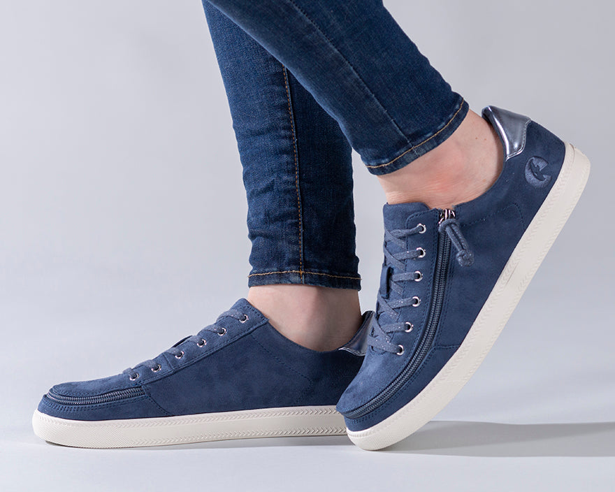 Women's Steel Blue BILLY Classic Lace Lows with faux suede, metallic heel accent, functional laces, and wraparound zipper for easy wear, shown on a person.