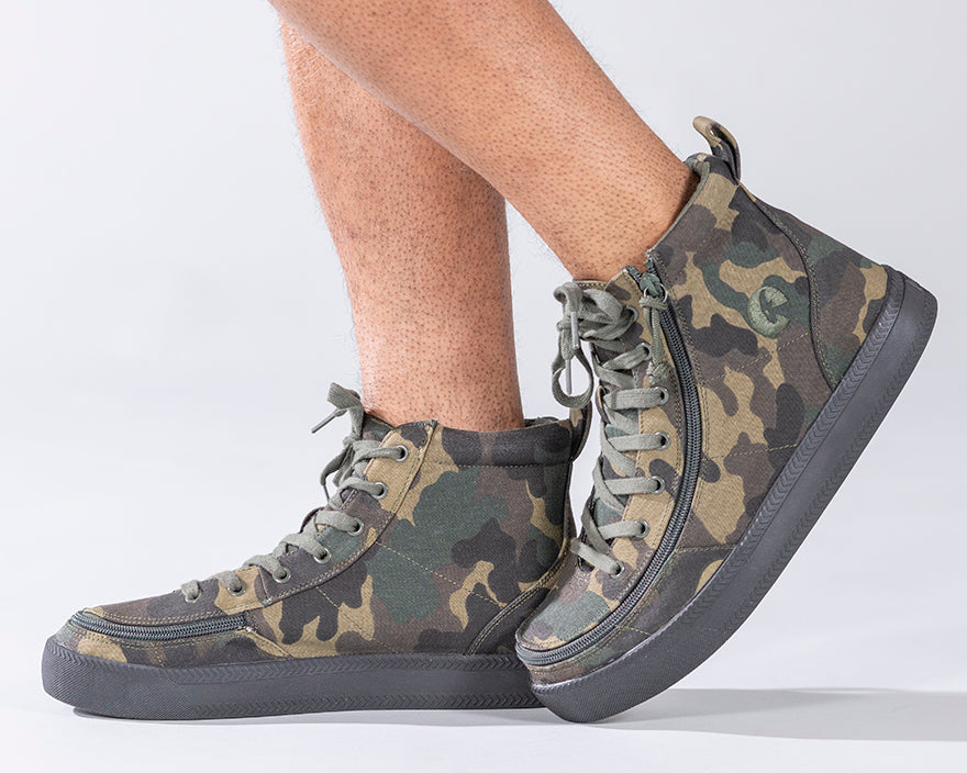 Men's Green Camo BILLY Classic Lace Highs, featuring adjustable laces, rubber outsole, and printed canvas upper, worn by a person, highlighting its stylish design.