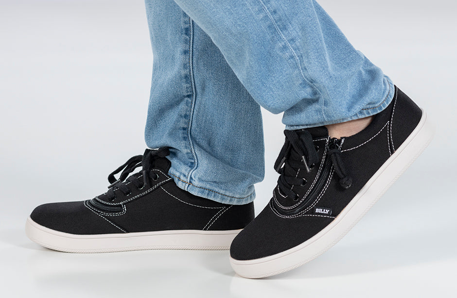 Men's Black/White Stitch BILLY Sneaker Low Tops with innovative zipper configuration, shown on a person wearing jeans, highlighting their casual and classic design.